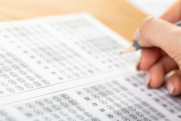 Obraz premium student hand test in exercise and passing examination paper computer worksheet with pencil in school test room, education concept