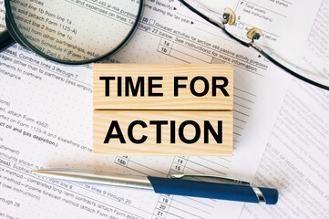 Wooden blocks with text Time For Action on financial docs
