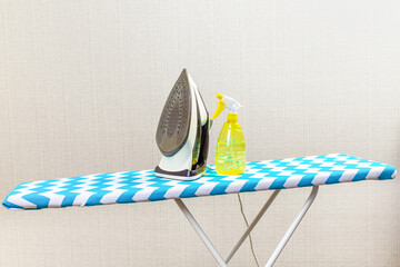 Electric clothes iron on the ironing board.