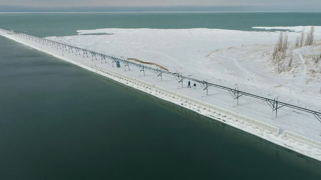 Aerial 4k shot of Frozen Lake Michigan Lighthouse and Pier. Location St. Joseph Michigan.