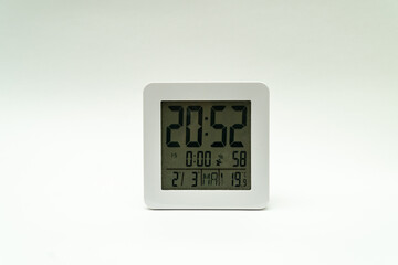 Closeup shot of a plain white alarm clock showing the time on a clean white background
