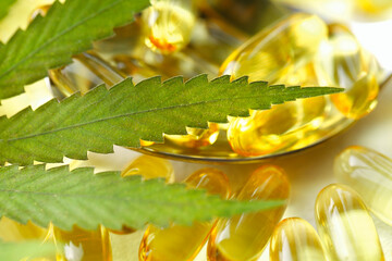 Cannabis CBD capsules are a medical cannabis product with leaves, CBD hemp oil capsules, on white background with copy space