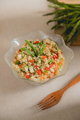 Fresh summer quinoa salad on glass bowl with wooden fork
