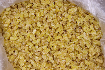 organic dried bulgur on a wood spoon
