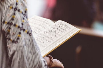 Female holding a book of sheet music