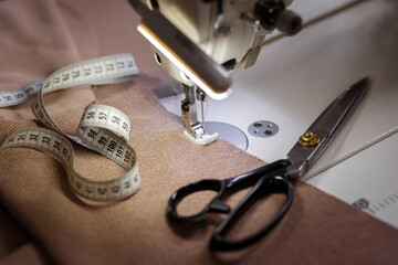 scissors, centimeter and sewing machine on the table