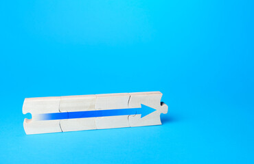 Assembled puzzle with a blue arrow. Continuation of process, further progress. Moving forward, direction of development. Career growth concept, promotion. Ensuring growth and expansion.