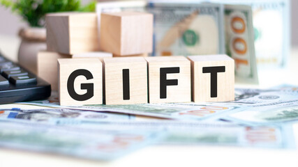 wooden blocks with text gift and banknotes on table, concept