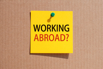 working abroad written on yellow paper and pinned on corkboard,