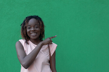 A Young beautiful happy African American woman on a green background