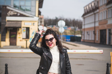 Beautiful young girl student hipster walks along the street of her city