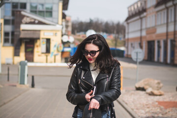Obraz premium Beautiful young girl student hipster walks along the street of her city