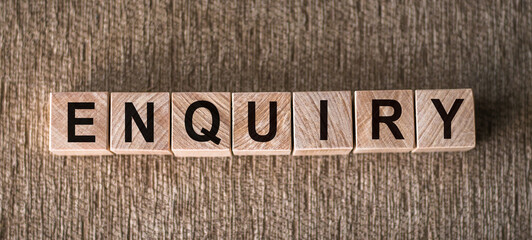ENQUIRY word written on wooden blocks on a brown background.