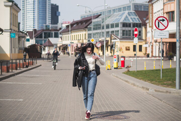 Beautiful young girl student hipster walks along the street of her city