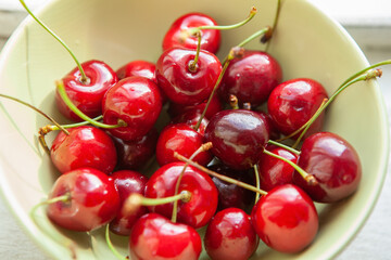 Juicy, ripe, fresh, red cherries in bowl, close-up. Concept healthy food, nutrition, vegetarianism, beneficial properties of seasonal berries, spring, summer harvest. Top view, soft selective focus
