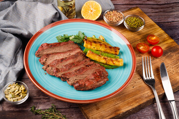 Sliced sirloin Steak Roast Beef on a dark wooden table background.