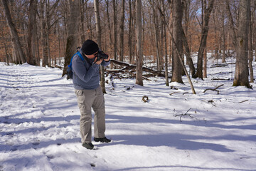 Young Photographer Taking Photos in Snowy Forest