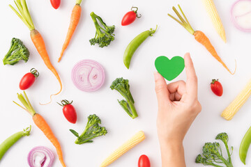 Combinations of vegan, Plant based foods such as vegetables and plant protein arranging beautifully in pattern on white background with a wooden spoon and green heart under alphabet letter 