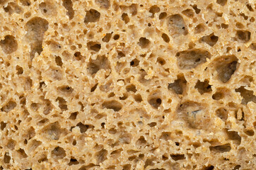 Surface of a fresh cut rye bread, close-up from above. Brown colored sourdough bread, a mix of rye grain flour, leaven and spices, baked in an oven. Staple food. Isolated over white, macro food photo.