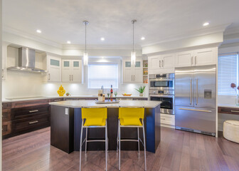Modern, bright, clean, kitchen interior with stainless steel appliances in a luxury house