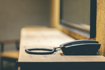 Jail telephone on a table next to the window glass