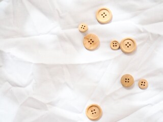Simple wooden buttons on a bright white textured background