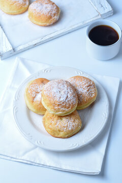sweet bombolone or Krapfen (or berliner, or doughnut ) made from yeast dough fried, with chocolate curd filling, powdered conventional sugar on top.