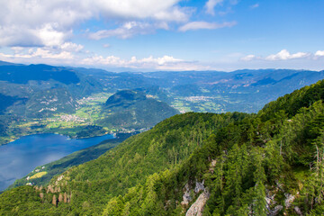 Fototapeta na wymiar Sunny view over Slovenian mountains from high Vogel mountain near cable railway of Vogel Ski Center in summer day. Bohinj valley with lake from top.