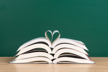 open books with a heart on a green background