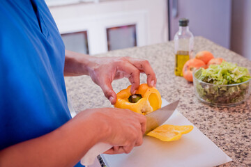 man chopping vagetables in the kitchen to make a delicious salad, cooking