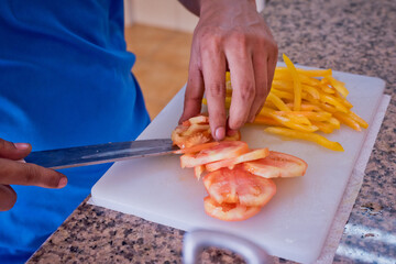 man chopping vagetables in the kitchen to make a delicious salad, cooking