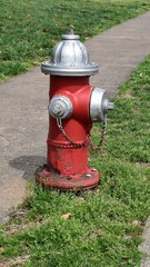 Fototapeta na wymiar Red Fire Hydrant with Silver Trim in a Suburban Neighborhood, Portrait Orientation