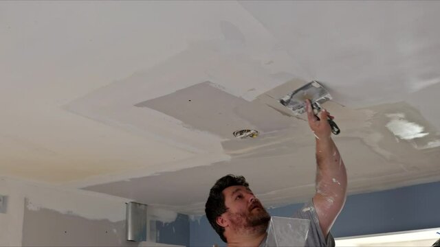 Plastering wall coating putty plaster on the ceiling on home interior renovation
