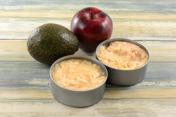 Avocado, apple and two cans of canned albacore tuna soaked in water ingredients for preparing tuna salad