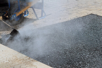Road worker repair asphalt covering new road surface