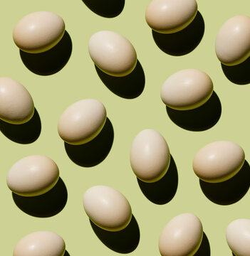 Chicken eggs on green background Pattern
