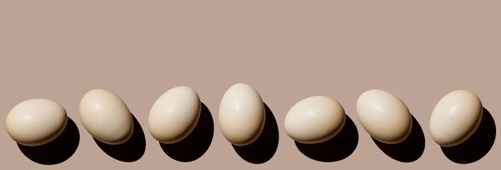 Chicken eggs on beige background copy space