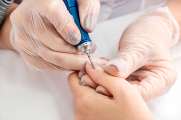 Close-up of female hands during a manicure procedure in the salon.