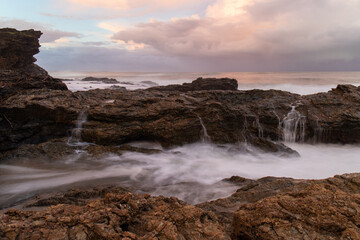 Water flowing into the channel between rock formation.