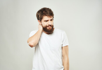 A man in a white T-shirt gestures with his hands on a light background cropped view of the emotion model