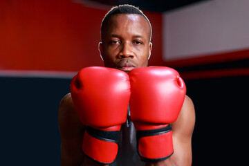 Portrait young fit strong black African man wearing boxing gloves standing getting ready to do boxing, healthy recreation lifestyle.