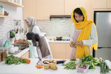 two attractive young muslim woman preparing iftar dinner together. Ramadan and eid mubarak cooking in the kitchen