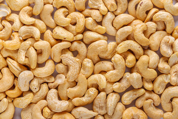 Pile of peeled cashew  as texture background. Healthy vegetarian snacks. Protein-containing foo