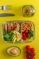 Lunch box with chicken, avocado, cucumber, tomato and spinach