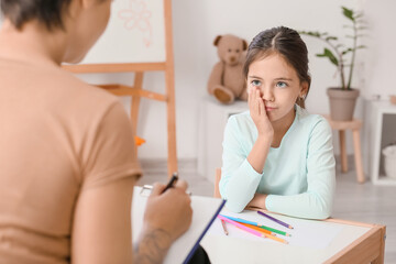 Sad little girl during psychotherapy session at home