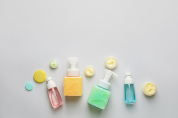 Composition with bottles of cosmetic products on light background