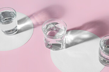 Creative composition with glasses of water on color background