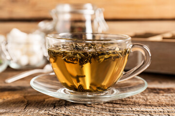 Cup of hot green tea on wooden background