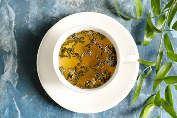 Cup of hot green tea on color background