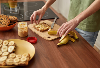 Young caucasian man cutting banana for snack